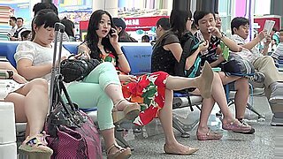 Eine asiatische Schönheit zeigt ihre Füße in einer öffentlichen Begegnung auf einem Flughafen.