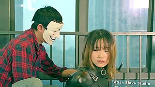 Uma mulher japonesa em um macacão de látex vermelho fica safada.