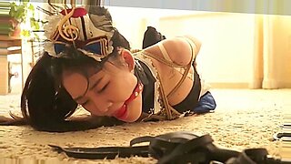 Ein süßes asiatisches Mädchen erlebt intensive Bondage und BDSM in einem JAV-Video.